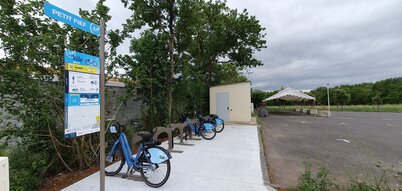 Station VLS « Petit Fief » avec vélos bleus garés sur leurs bornes et panneau d'information du service