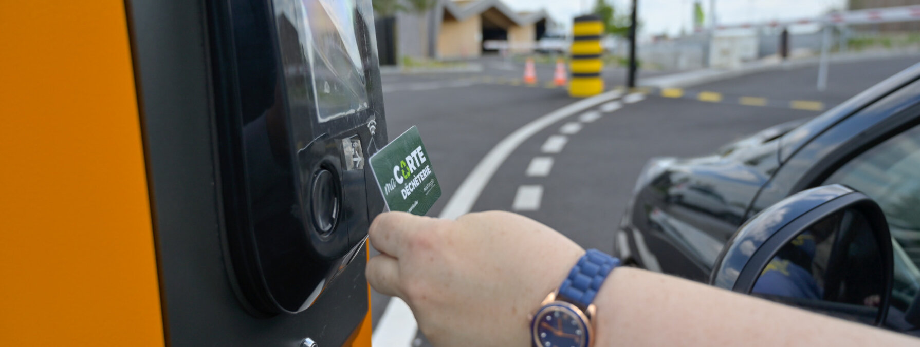 Main d'un usager présentant sa carte déchèterie à la borne d'accès depuis un véhicule