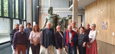 Le nouveau conseil d'administration des Amis des musées de Niort, avec sa présidente Catherine Piot, posant devant une statue en bronze au musée.