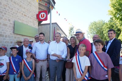 Coupure du ruban inaugural devant l'enseigne Super U, avec élus portant l'écharpe tricolore et habitants de Fors
