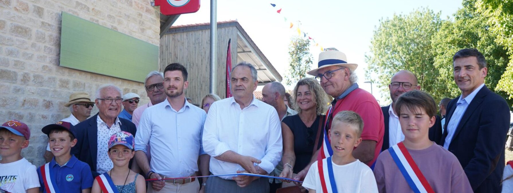 Coupure du ruban inaugural devant l'enseigne Super U, avec élus portant l'écharpe tricolore et habitants de Fors