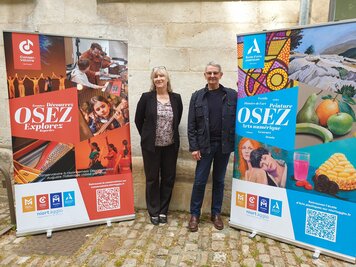 Le Vice président en charge de la culture, et une F. Beguin posent devant les kakémonos du Conservatoire Auguste-Tolbecque et de l'École d'arts plastiques
