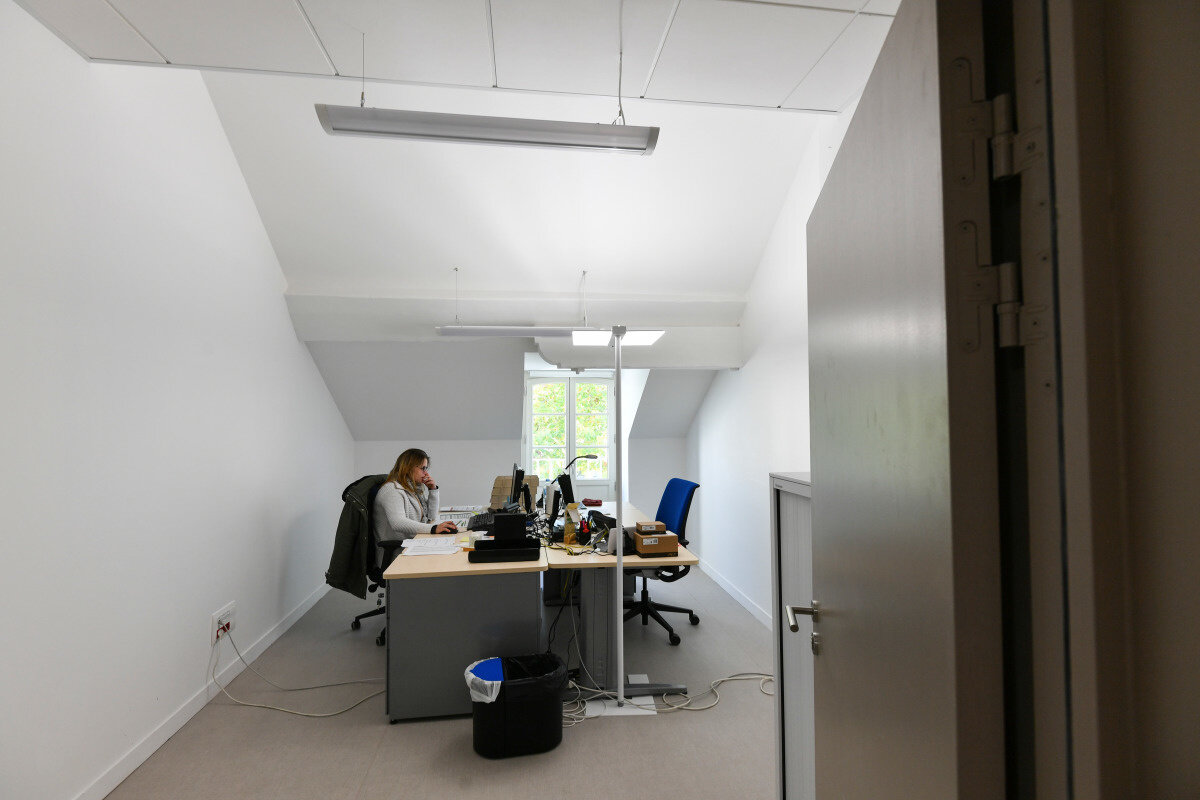 Agent administratif du Conservatoire de Niort au bureau, travaillant sur ordinateur et téléphonant dans un espace lumineux