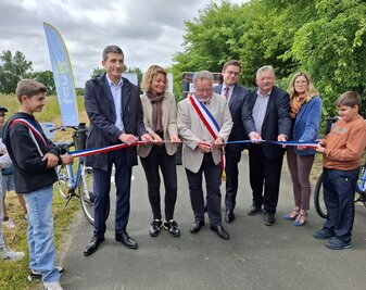 Jérôme Baloge, président de Niort Agglo, coupe le ruban tricolore avec des élus locaux, entouré d'enfants sur la piste