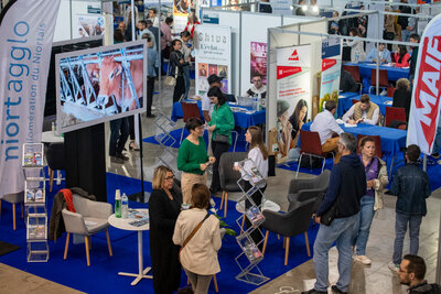 Hall d'exposition avec stands d'employeurs — Niort Agglo, MAIF, Shiva — et visiteurs en entretien