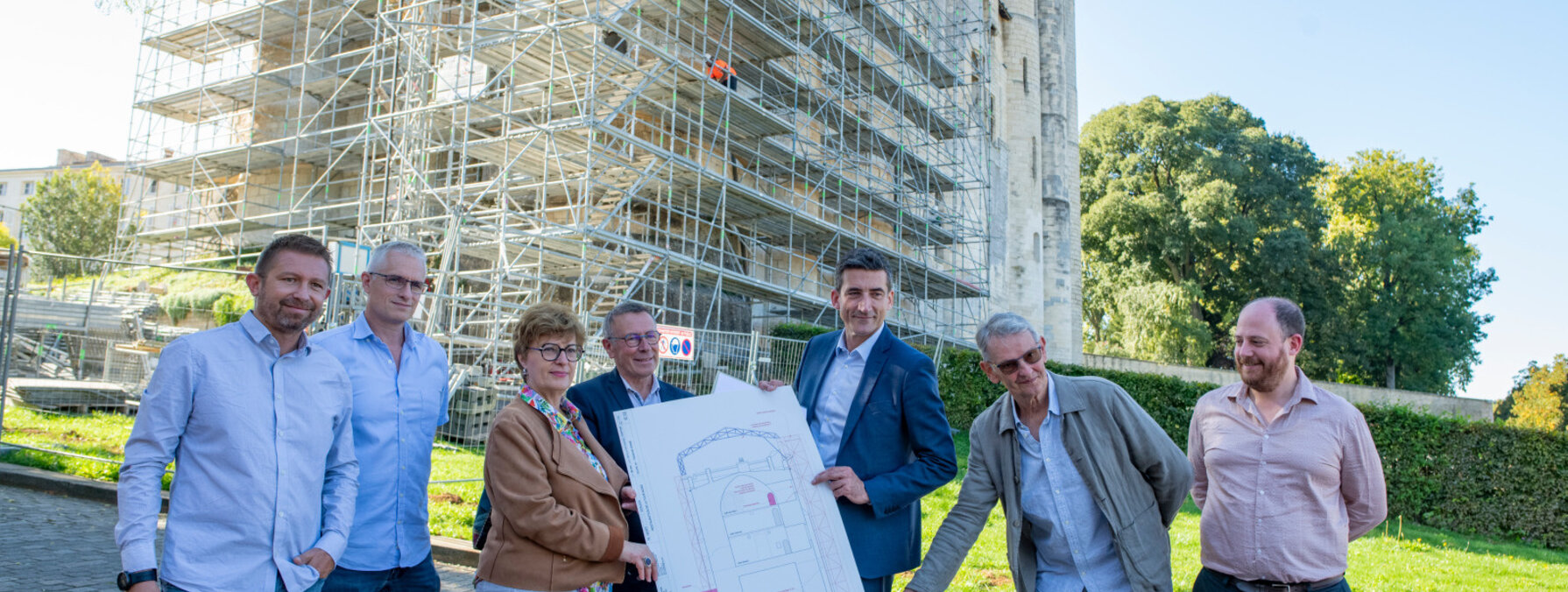 Jérôme Baloge et les acteurs du chantier consultent des plans devant l'échafaudage de la tour nord