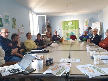 Une dizaine de participants en séance de travail autour de tables, bannière Projet Alimentaire Territorial NiortAgglo visible en fond